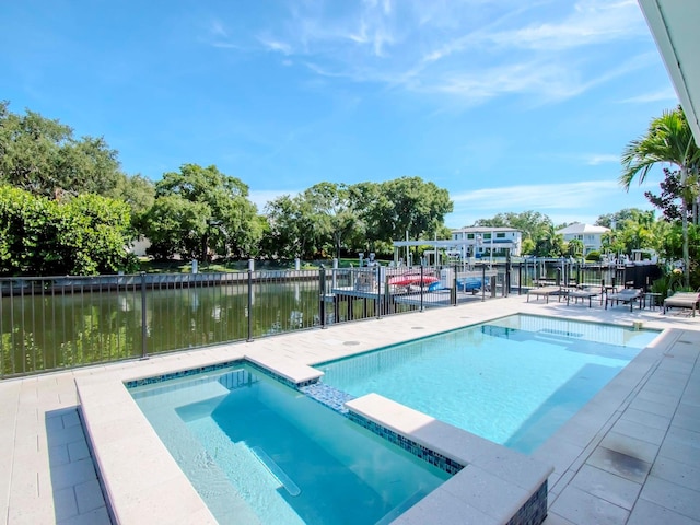 view of swimming pool featuring an in ground hot tub and a water view