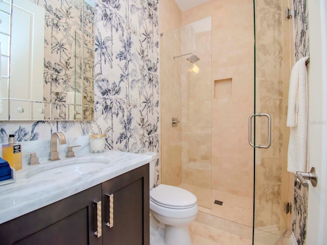 bathroom featuring an enclosed shower, vanity, and toilet