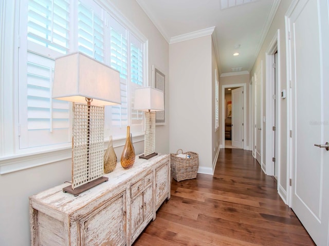 corridor with a healthy amount of sunlight, ornamental molding, and hardwood / wood-style floors