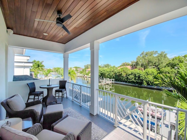 sunroom featuring wooden ceiling, a water view, and ceiling fan