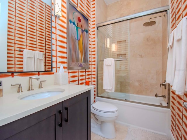 full bathroom with toilet, bath / shower combo with glass door, and vanity