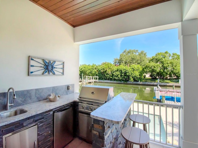 view of patio / terrace with a swimming pool, area for grilling, a water view, and sink