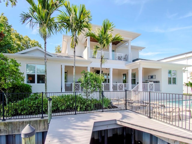 rear view of property with a fenced in pool