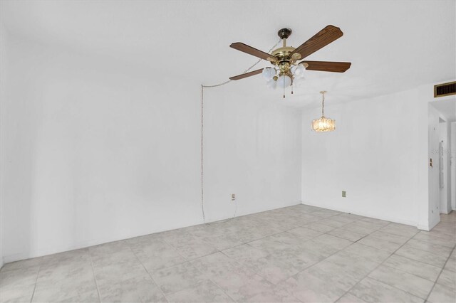 empty room featuring ceiling fan with notable chandelier