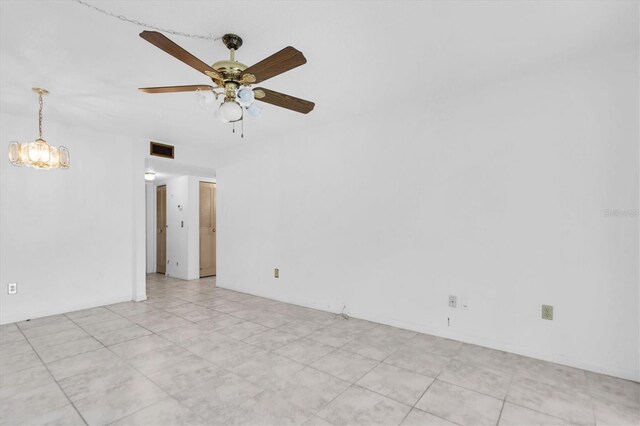 empty room featuring ceiling fan with notable chandelier