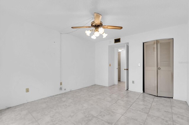 unfurnished bedroom featuring ceiling fan and a closet