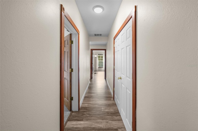 hallway with dark hardwood / wood-style flooring