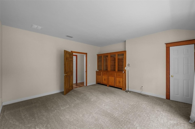 unfurnished bedroom with carpet and vaulted ceiling