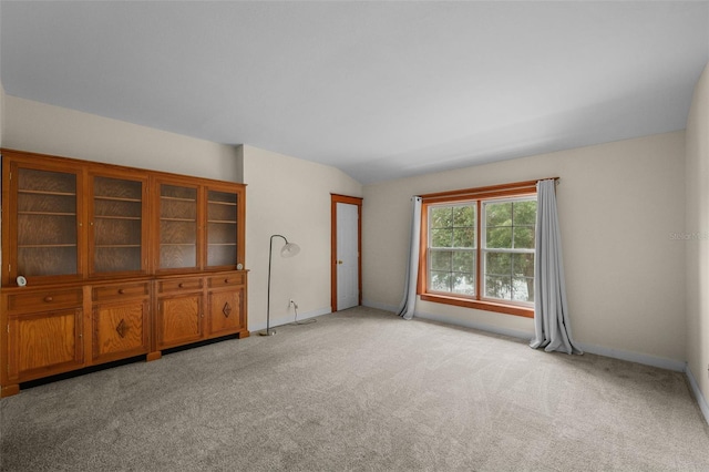 empty room with light carpet and vaulted ceiling