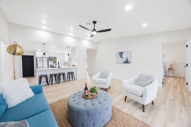 living room featuring light hardwood / wood-style flooring and ceiling fan