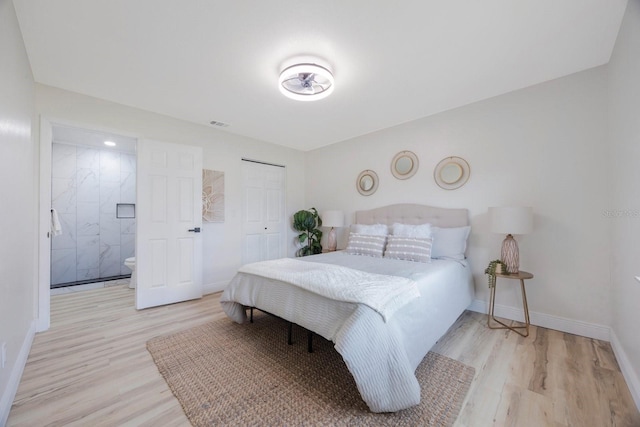 bedroom with a closet, connected bathroom, and light hardwood / wood-style floors