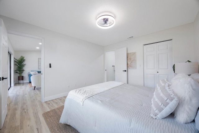 bedroom with light wood-type flooring and a closet