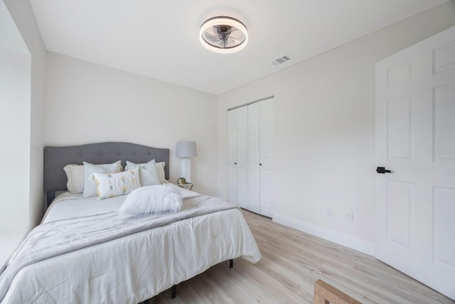 bedroom with light wood-type flooring and a closet