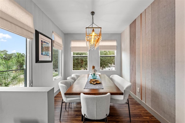 dining room with dark hardwood / wood-style flooring and an inviting chandelier