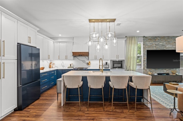 kitchen featuring black refrigerator, sink, white cabinets, and blue cabinets