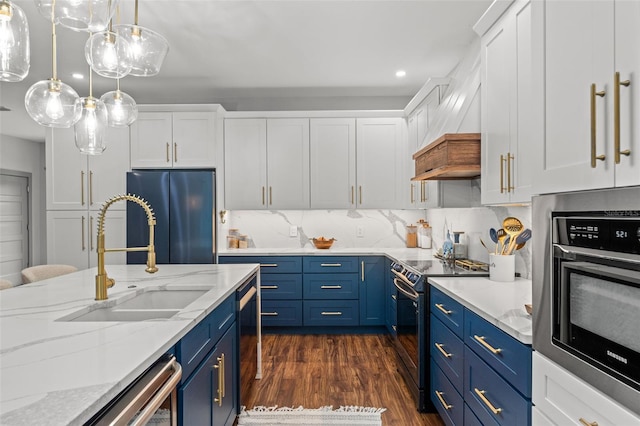 kitchen with black electric range oven, sink, white cabinetry, fridge, and blue cabinets