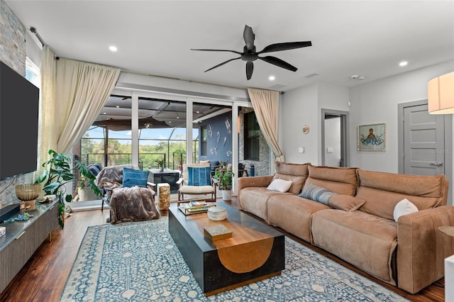 living room featuring dark hardwood / wood-style flooring, a wealth of natural light, and ceiling fan