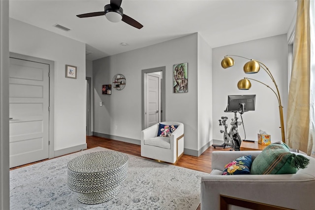 living room featuring wood-type flooring and ceiling fan