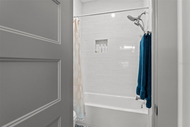 bathroom featuring toilet and shower / bathtub combination with curtain