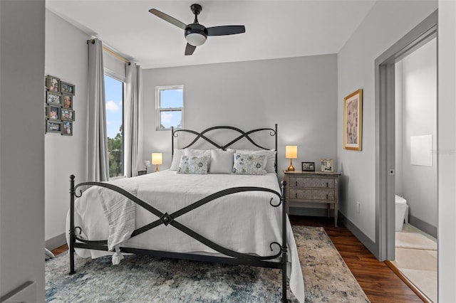 bedroom with ceiling fan, dark hardwood / wood-style flooring, and ensuite bath