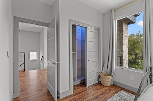 bedroom with dark wood-type flooring, a closet, and multiple windows