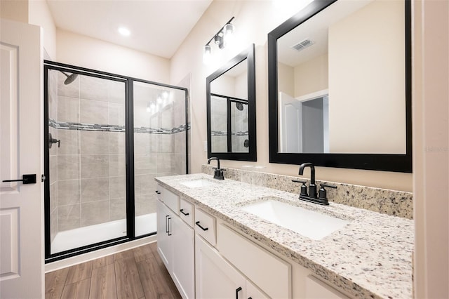 bathroom featuring vanity, an enclosed shower, and hardwood / wood-style flooring