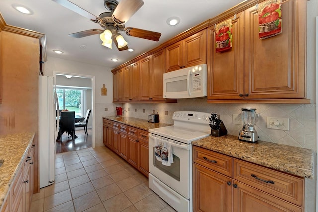 kitchen featuring light stone counters, light tile patterned flooring, white appliances, backsplash, and ceiling fan