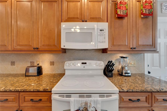 kitchen with backsplash, white appliances, and light stone countertops