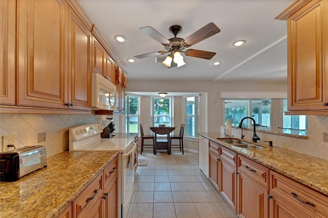 kitchen with white appliances, sink, ceiling fan, and a wealth of natural light