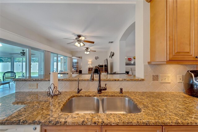 kitchen with ceiling fan and light stone countertops