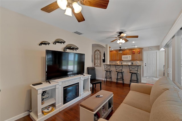 living room featuring ceiling fan and hardwood / wood-style floors