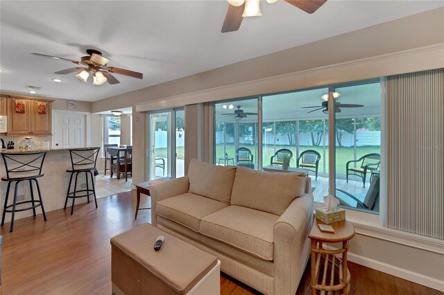 living room with light hardwood / wood-style floors and ceiling fan