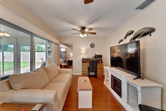 living room featuring ceiling fan and dark hardwood / wood-style flooring