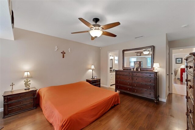 bedroom featuring ensuite bath, ceiling fan, and hardwood / wood-style floors