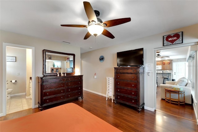 bedroom with ceiling fan, ensuite bathroom, and dark wood-type flooring