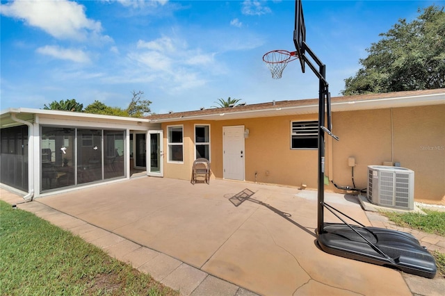 rear view of property with a sunroom, cooling unit, and a patio area