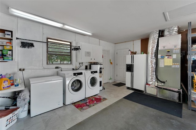 laundry area with washer and clothes dryer, water heater, and cabinets