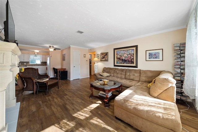 living room featuring ceiling fan, dark wood-type flooring, and crown molding