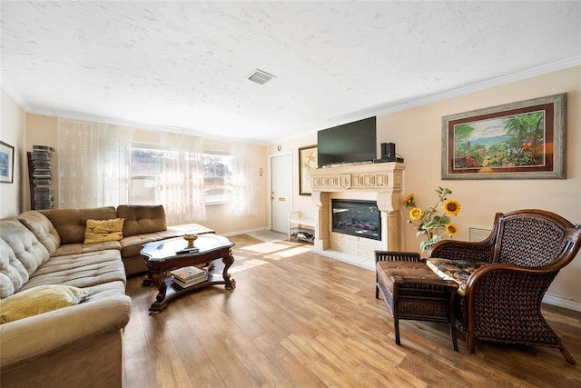 living room featuring a textured ceiling, crown molding, and light hardwood / wood-style floors