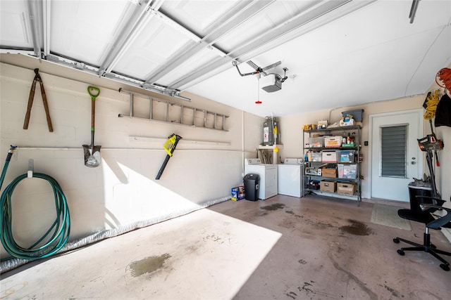 garage with a garage door opener, washer and dryer, and water heater