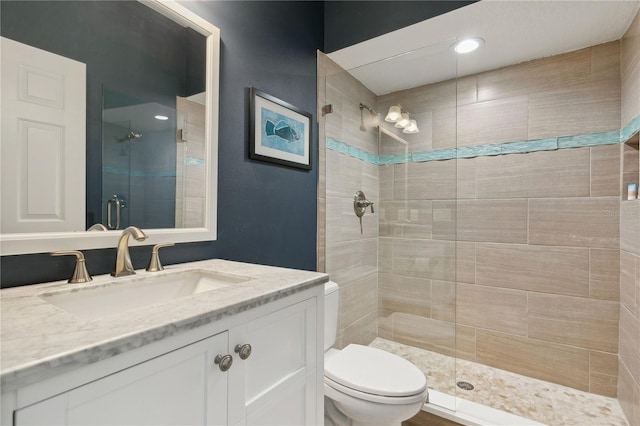 bathroom featuring vanity, toilet, and walk in shower