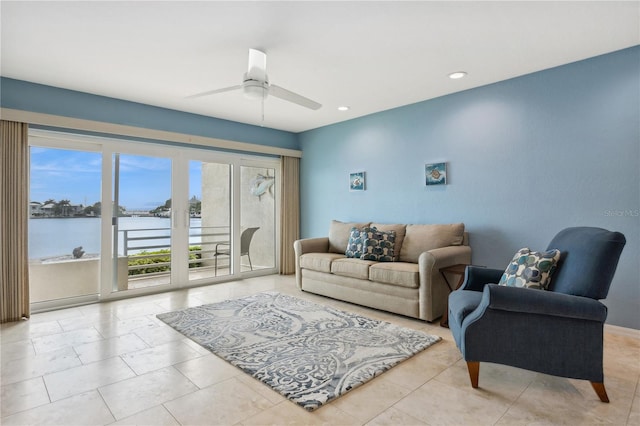 living room with a water view and ceiling fan