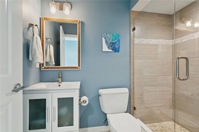 bathroom with vanity, toilet, and a shower with shower door