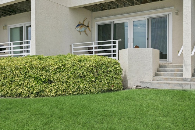 doorway to property featuring a lawn