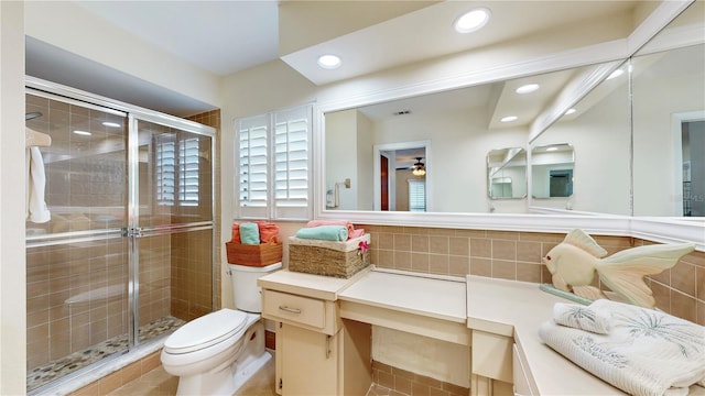 bathroom with tile patterned flooring, walk in shower, toilet, and vanity