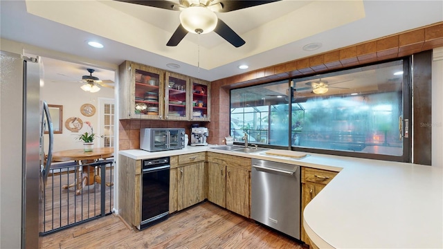 kitchen with sink, stainless steel appliances, ceiling fan, and light hardwood / wood-style floors