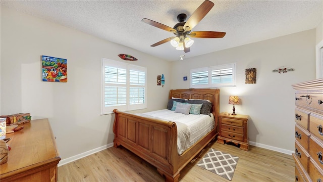 bedroom featuring light wood-type flooring, ceiling fan, and a textured ceiling