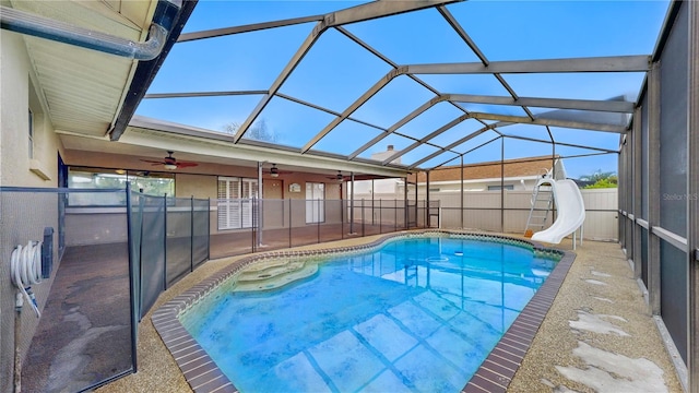 view of pool featuring a water slide, a patio area, glass enclosure, and ceiling fan