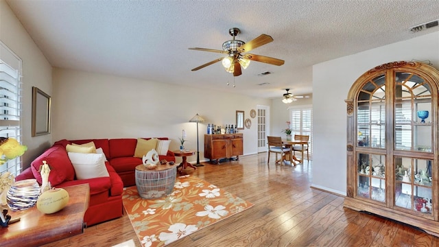 living room featuring a textured ceiling and light wood-type flooring