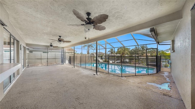 view of pool featuring a patio area, ceiling fan, and glass enclosure